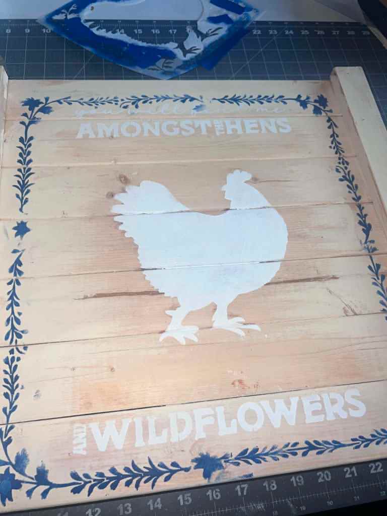 Solid white hen silhouette on the board, framed by the navy vine border